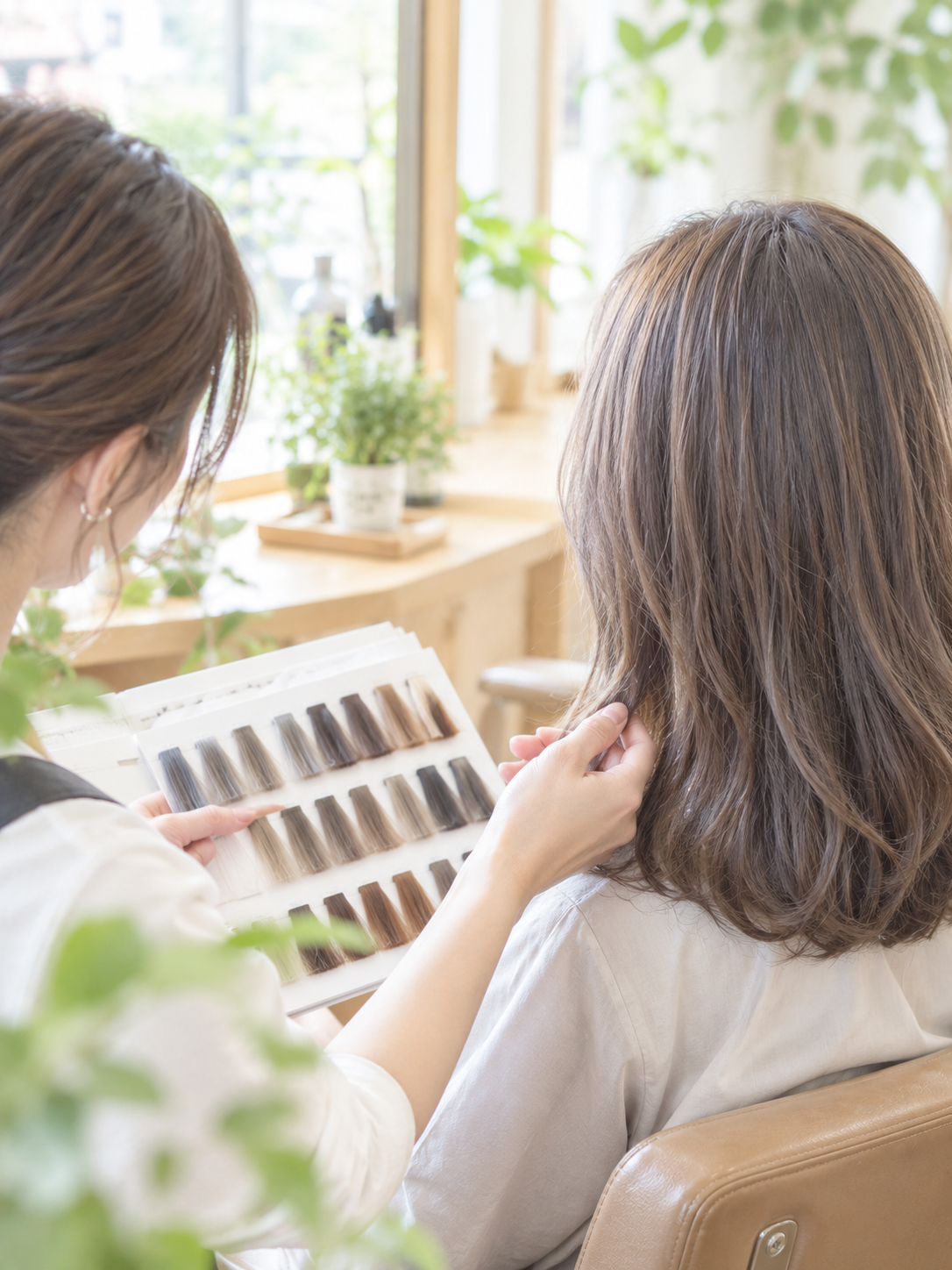 美染 倉吉店でフォギーカラー(FOGGYCOLOR)の色見本を見ながらカウンセリングをしている手元